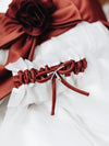 custom white main wedding garter with red detailing from bride's flower girl dress at mom's wedding handmade by The Garter Girl