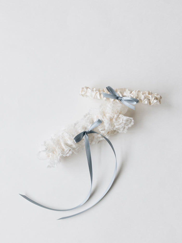 feminine wedding garter set with ivory lace and dusty blue bow main garter and ivory lace tossing garter handmade by The Garter Girl