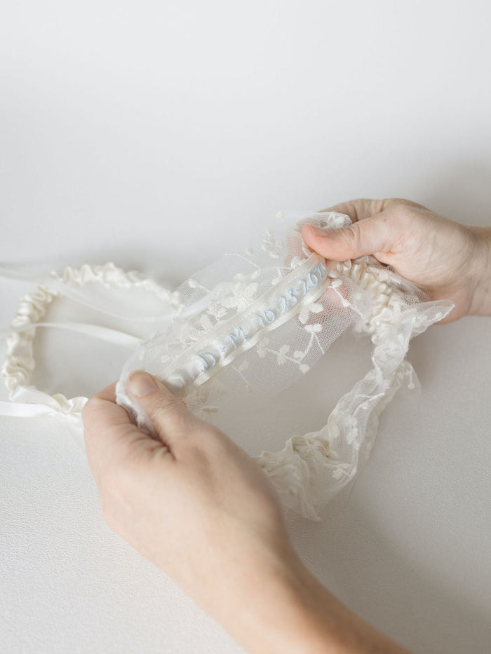 custom wedding garter handmade with floral embroidered tulle and couple's wedding date and initials sewn on the inside by expert heirloom designer The Garter Girl