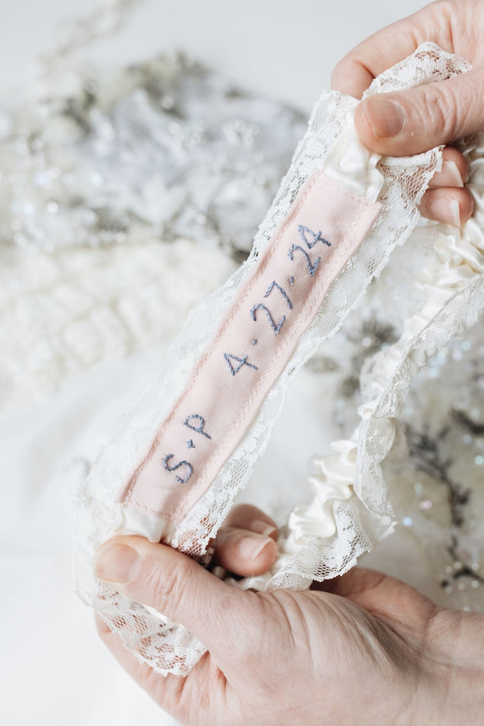 something blue embroidery atop a blush pink piece on an ivory satin wedding garter handmade from mom and grandmother's wedding dress by The Garter Girl