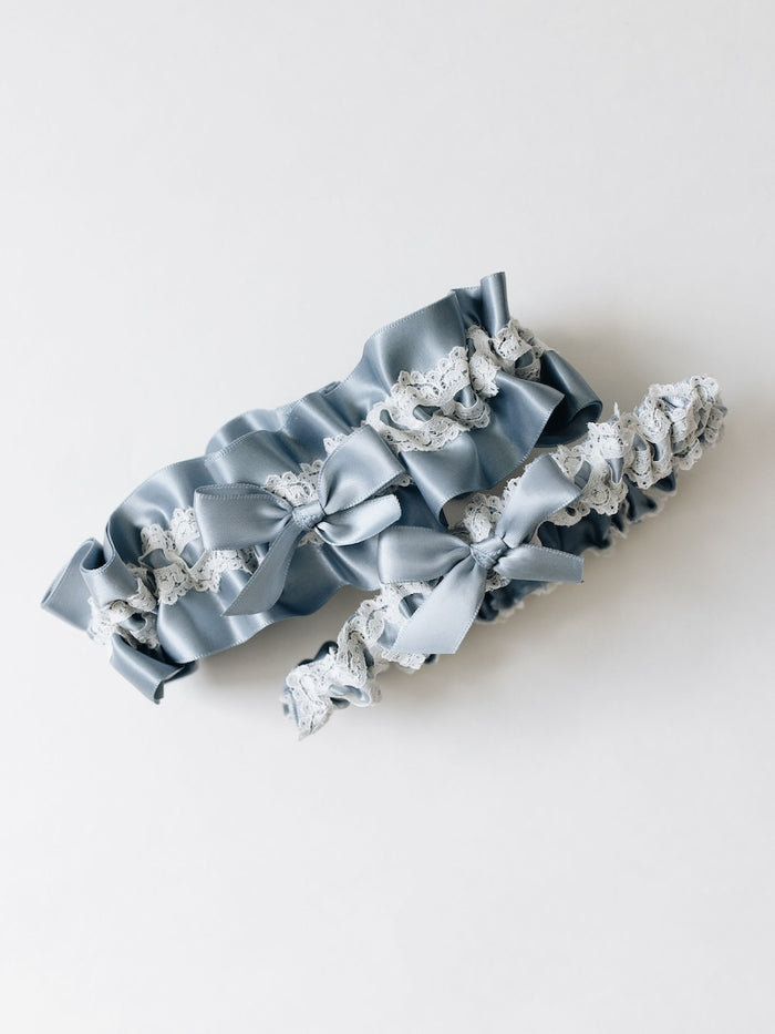 custom ivory lace and dusty blue satin wedding garter set with personalized embroidery and short tailed blue satin bows handmade by The Garter Girl