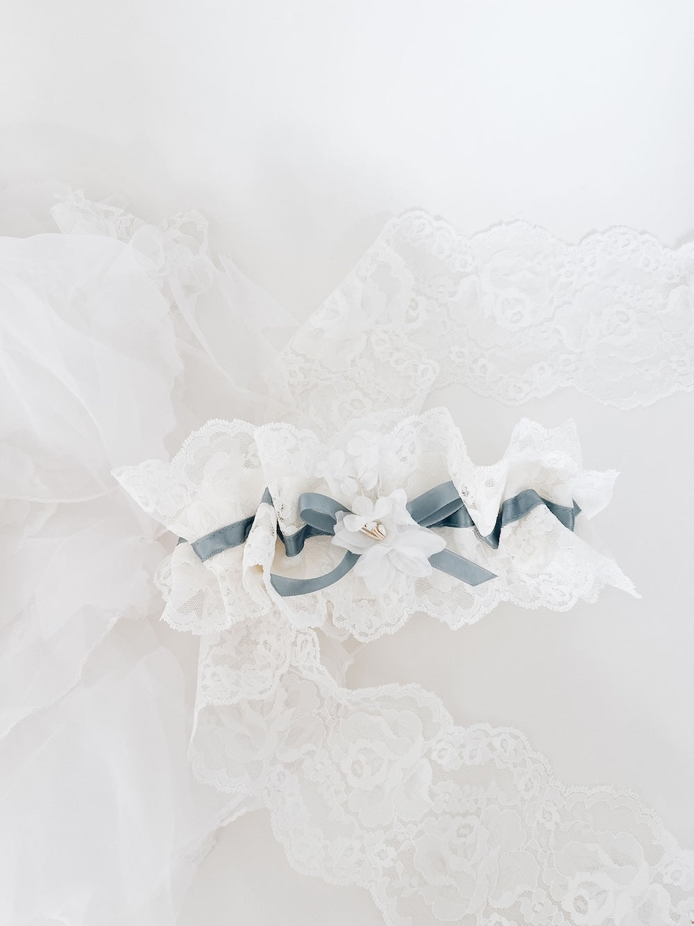 custom ivory lace wedding garter heirloom with dusty blue satin and flower detail from mother's wedding veil made by The Garter Girl