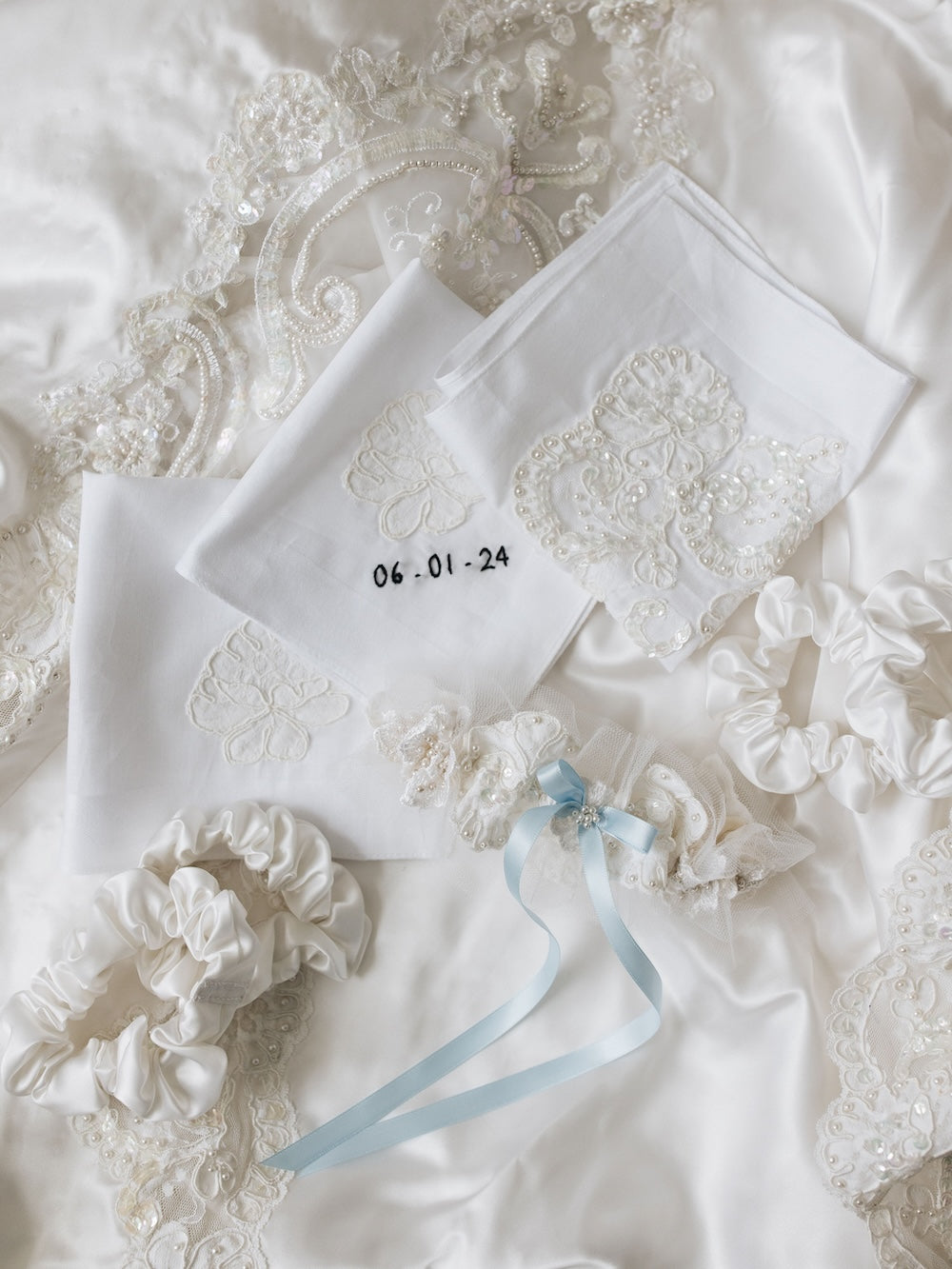 heirloom hair scrunchies for bridesmaids with embroidered handkerchiefs with wedding date and an ivory satin garter with tulle, pearls, and a blue satin bow all handmade from mother's wedding dress by The Garter Girl