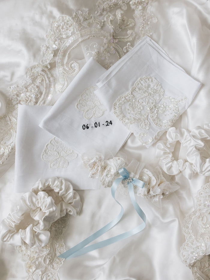 heirloom hair scrunchies for bridesmaids with embroidered handkerchiefs with wedding date and an ivory satin garter with tulle, pearls, and a blue satin bow all handmade from mother's wedding dress by The Garter Girl
