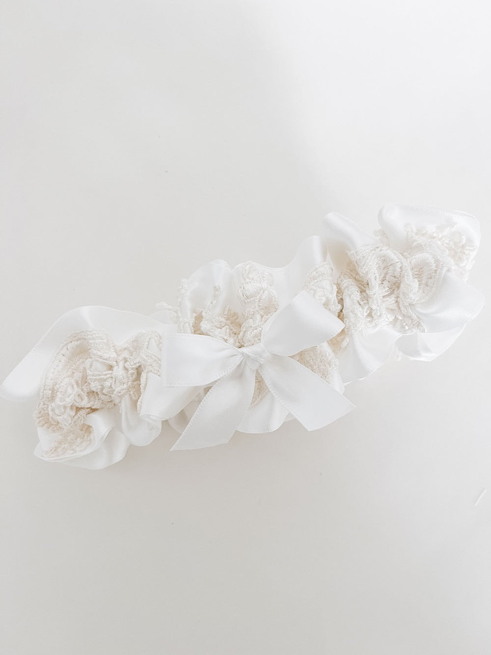 heirloom ivory satin keepsake wedding garter with a short ivory bow made with ivory lace from the bride's mother's wedding dress materials handmade by The Garter Girl