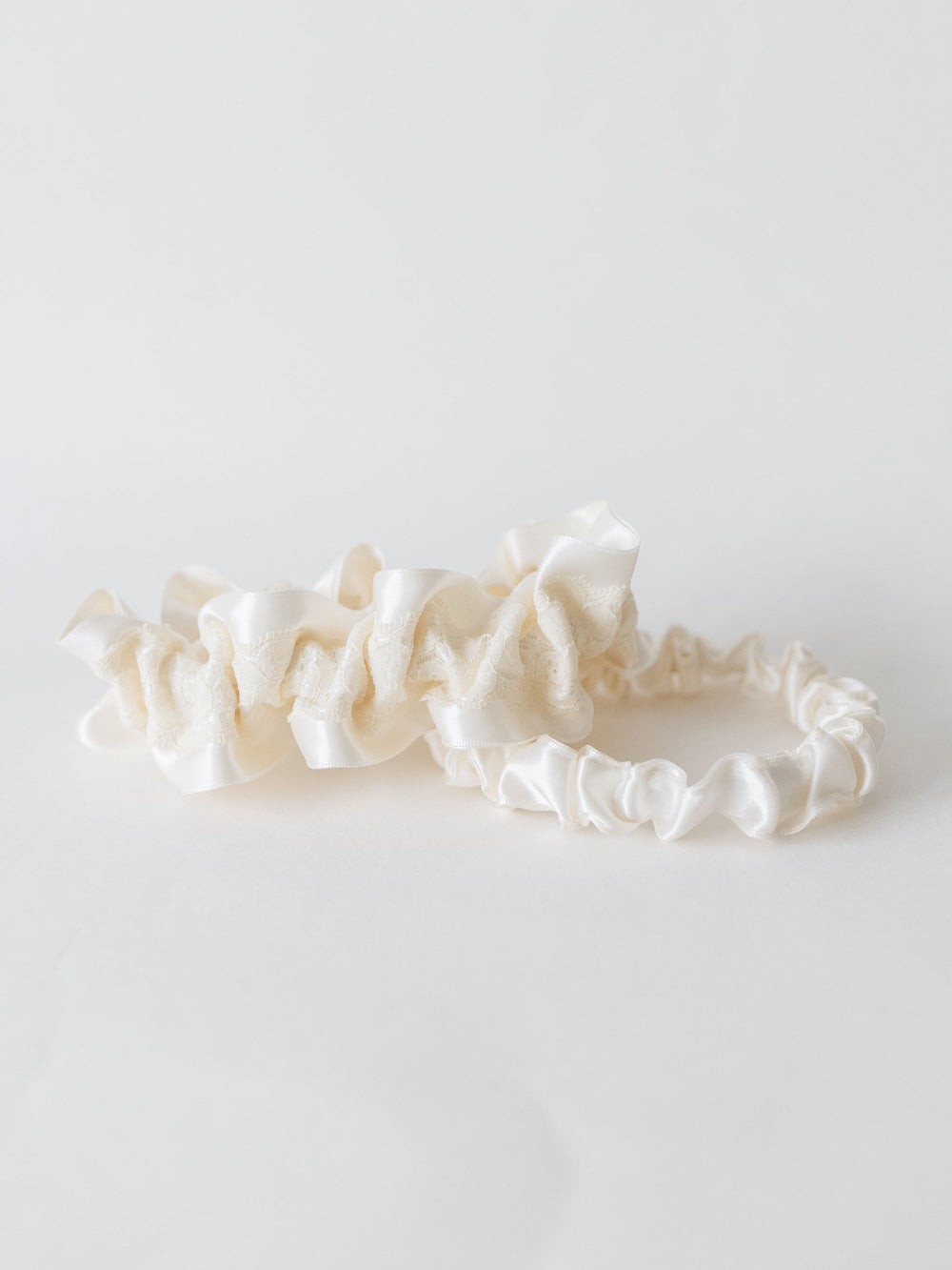 ivory wedding garter set with lace atop satin with main and tossing garter handmade by The Garter Girl