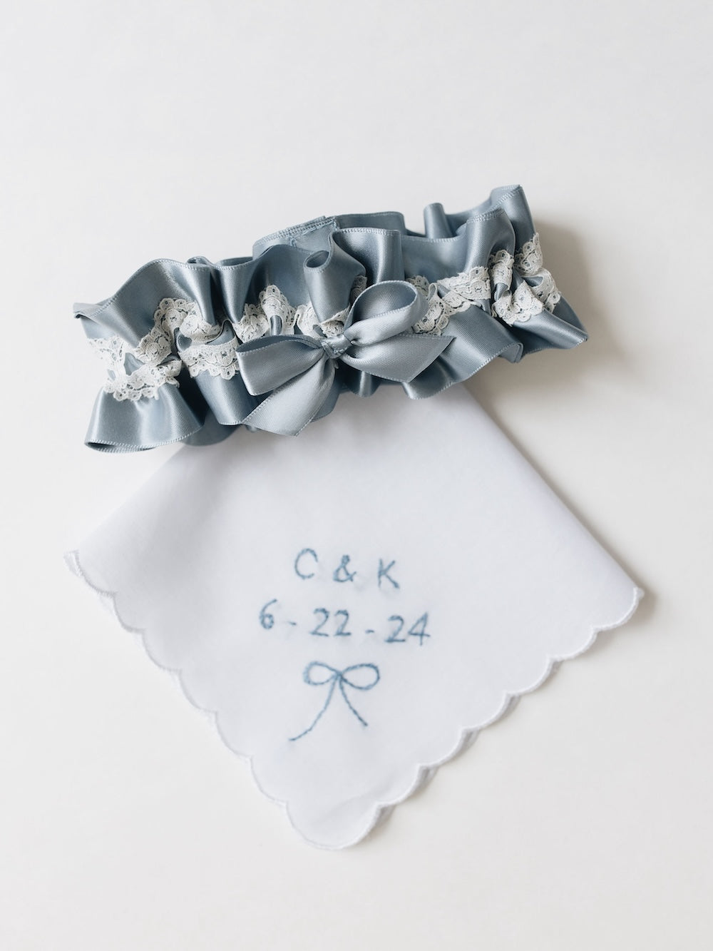 personalized wedding handkerchief with blue embroidery and a dusty blue satin wedding garter with ivory lace detailing handmade by The Garter Girl