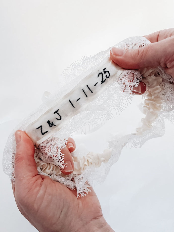 Custom wedding garter with romantic and delicate ivory lace and personalized hand embroidery in black made by the top wedding garter designer, The Garter Girl