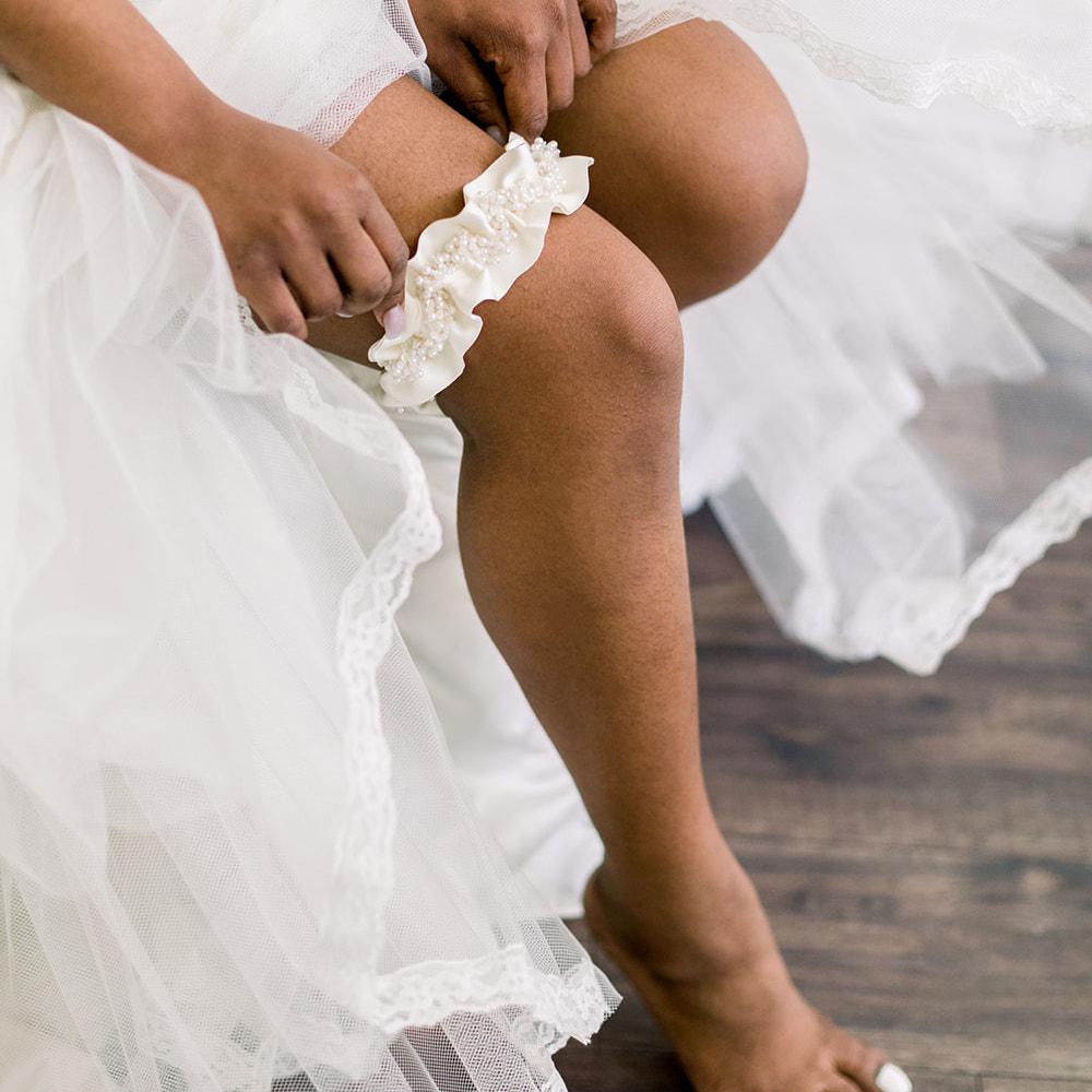 Shop our heirloom bridal garter with faux pearls, beads and ivory satin.