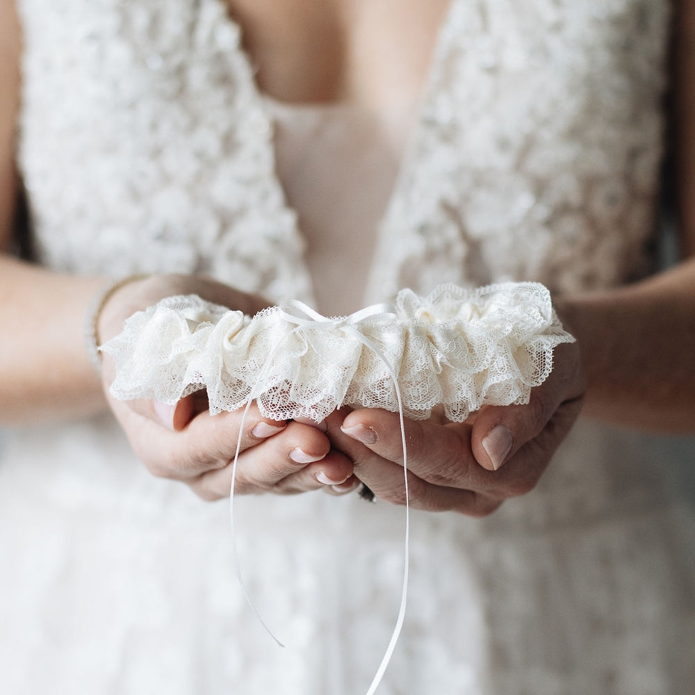 Shop our heirloom wedding garter with ivory lace and bow.