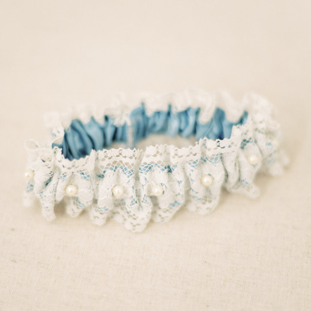 Shop our heirloom lace wedding garter, featuring pearls and vintage style.