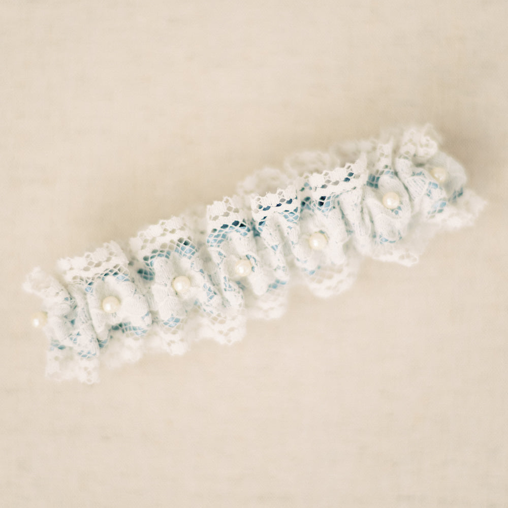 Shop our heirloom lace wedding garter, featuring pearls and vintage style.