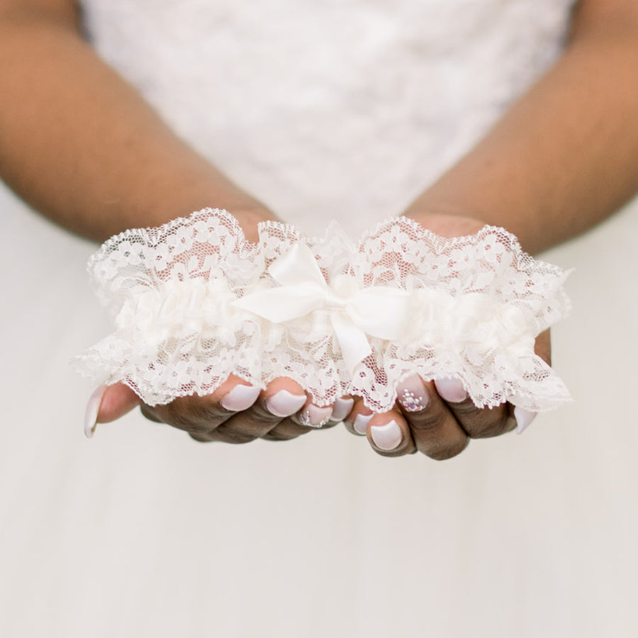 Shop our heirloom wedding garter with floral ivory lace and satin bow.