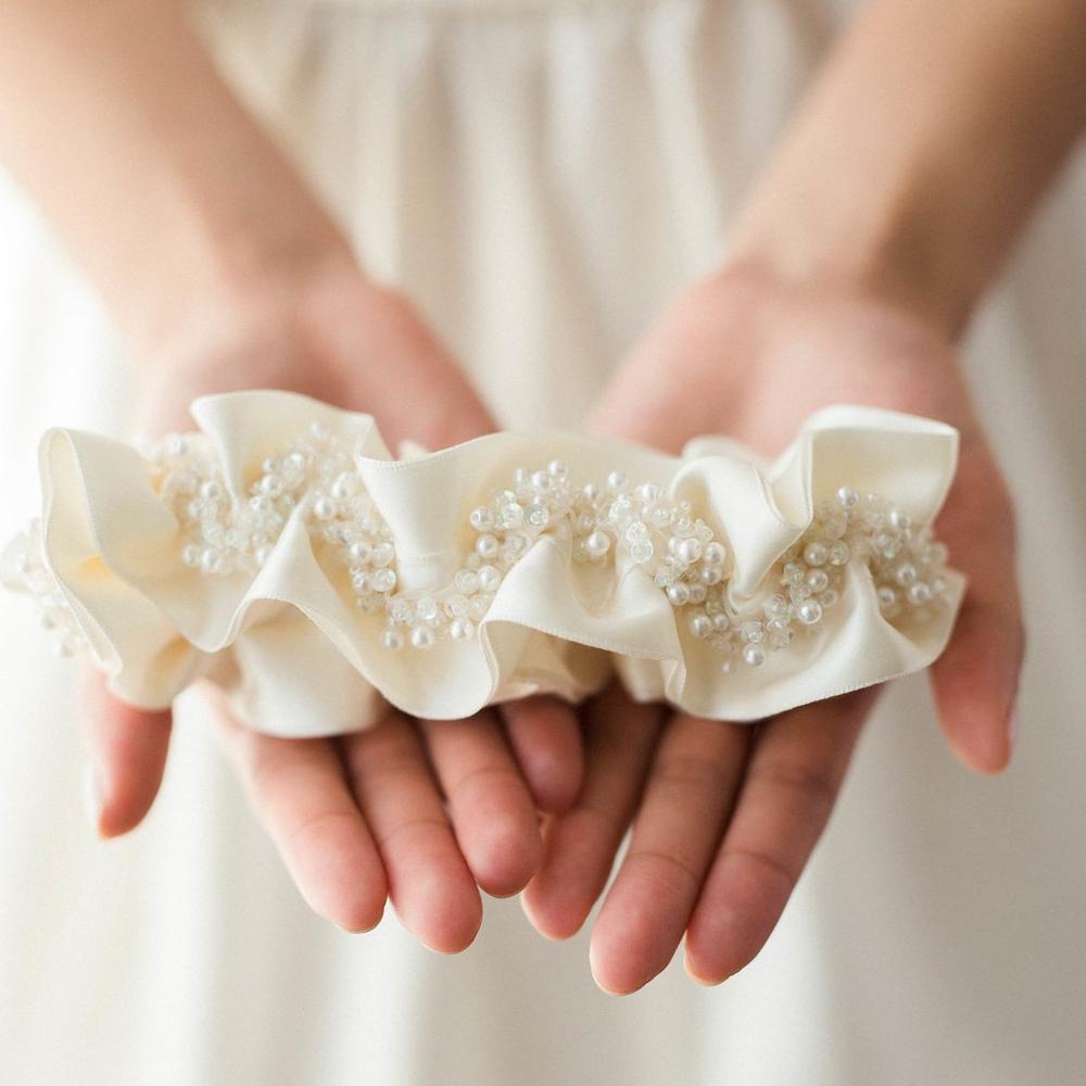 Shop our heirloom bridal garter with faux pearls, beads and ivory satin.