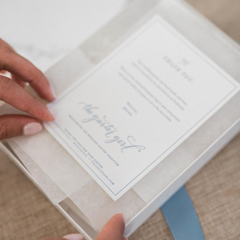 Shop our heirloom ivory satin and lace bridal garter with elegant blue ribbon.